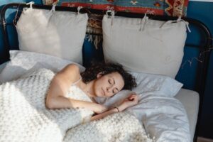 dormir grâce à la sophrologie-  femme en train de dormir paisiblement dans son lit